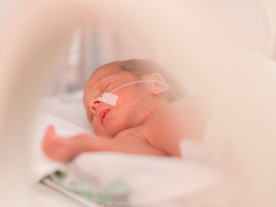 Photograph of small, premature infant in the NICU.