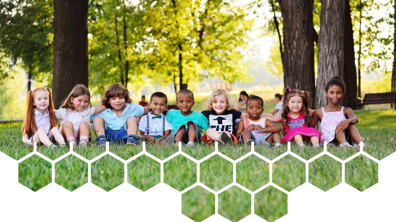 Photograph of 9 kids sitting on the grass in front of a few trees outdoors at golden hour with Data Informed Futures logo applied as overlay on photo.